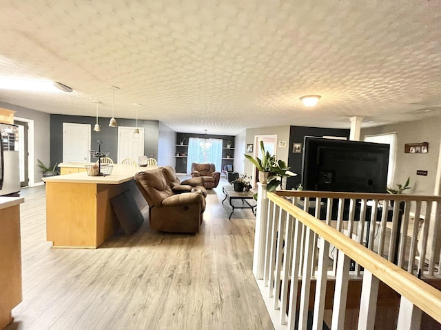 living room with a textured ceiling and light wood-type flooring