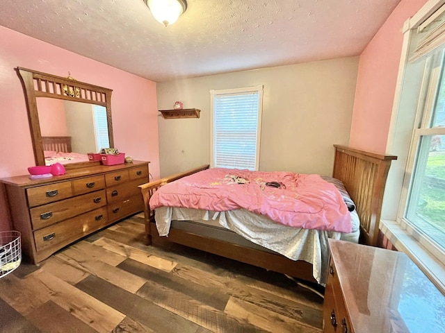 bedroom featuring dark hardwood / wood-style flooring and a textured ceiling