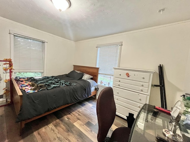 bedroom with hardwood / wood-style floors and crown molding