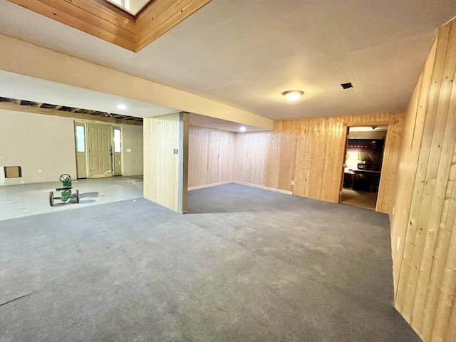 basement featuring wooden walls and carpet floors