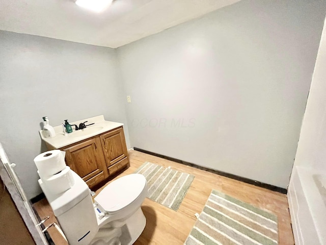 bathroom featuring hardwood / wood-style flooring, vanity, and toilet