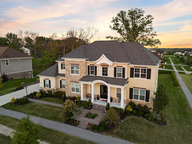 view of front of property with covered porch and a lawn