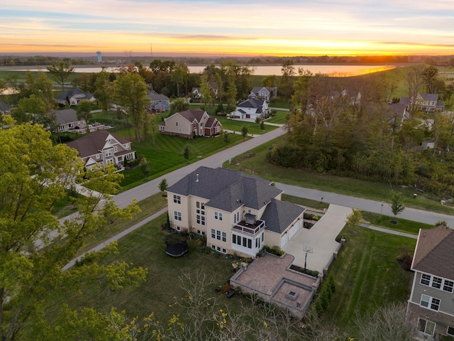 aerial view at dusk featuring a water view