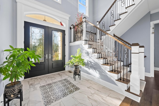 entrance foyer featuring hardwood / wood-style floors, crown molding, and french doors