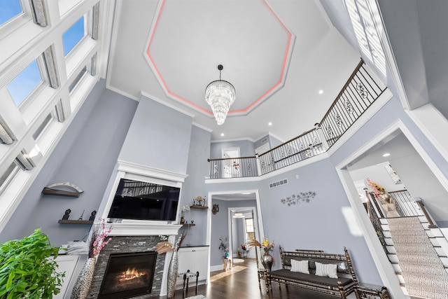 living room featuring hardwood / wood-style floors, a notable chandelier, a towering ceiling, and a wealth of natural light