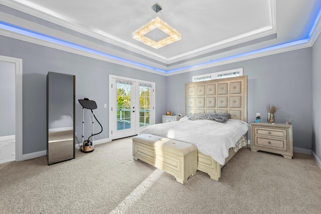 carpeted bedroom with a raised ceiling, crown molding, french doors, and access to outside