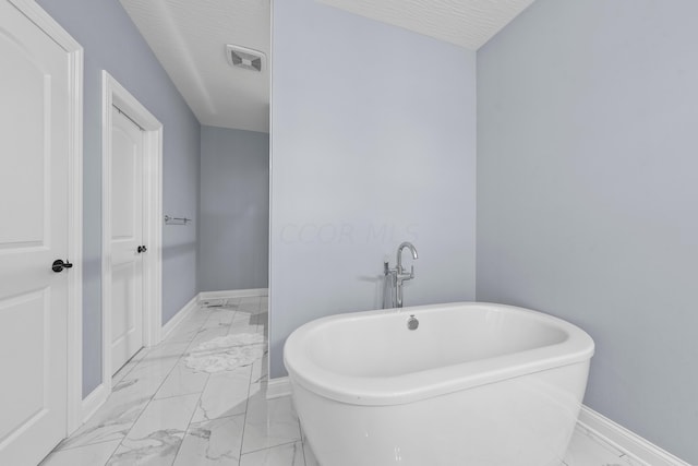 bathroom featuring a textured ceiling and a bathing tub