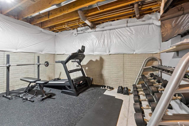 exercise room featuring brick wall