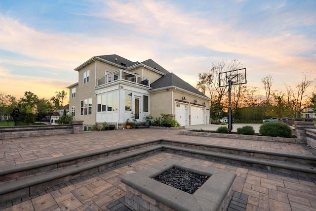 view of front of home featuring a patio area, a balcony, and a fire pit