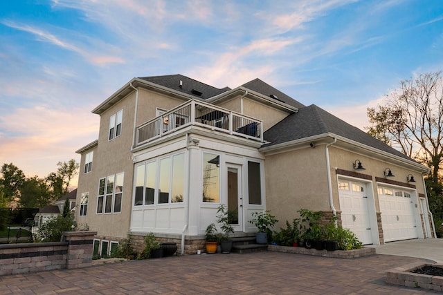 view of front of house featuring a garage and a balcony