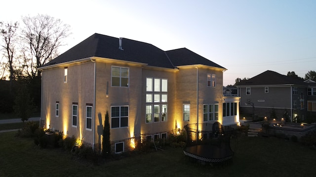 view of back house at dusk