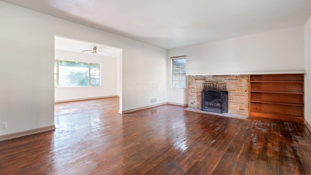 unfurnished living room featuring a fireplace, dark hardwood / wood-style floors, and ceiling fan