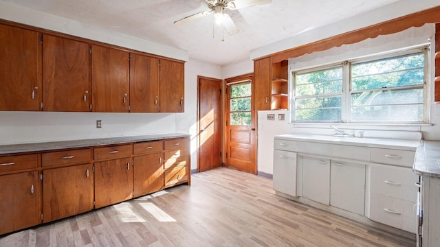 kitchen with ceiling fan, sink, and light hardwood / wood-style floors