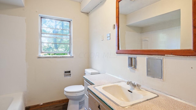 bathroom with vanity, a bathtub, and toilet