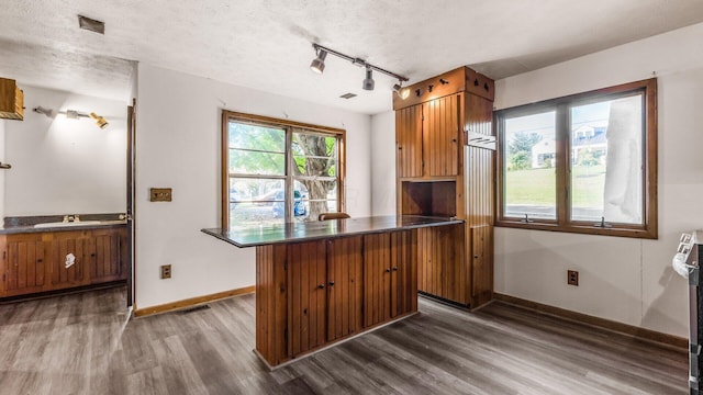 kitchen with a kitchen breakfast bar, dark hardwood / wood-style floors, sink, and a textured ceiling