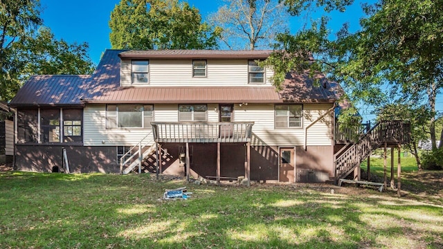 rear view of property featuring a sunroom, a deck, and a yard