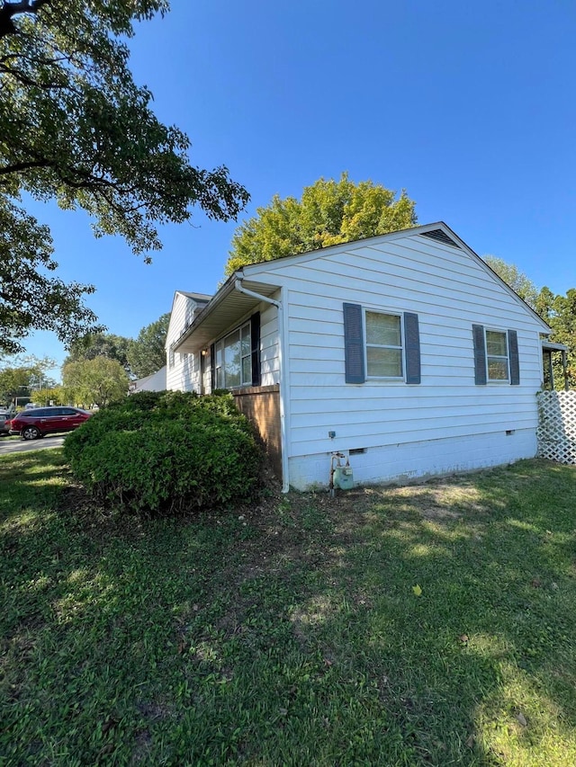 view of side of home with a yard