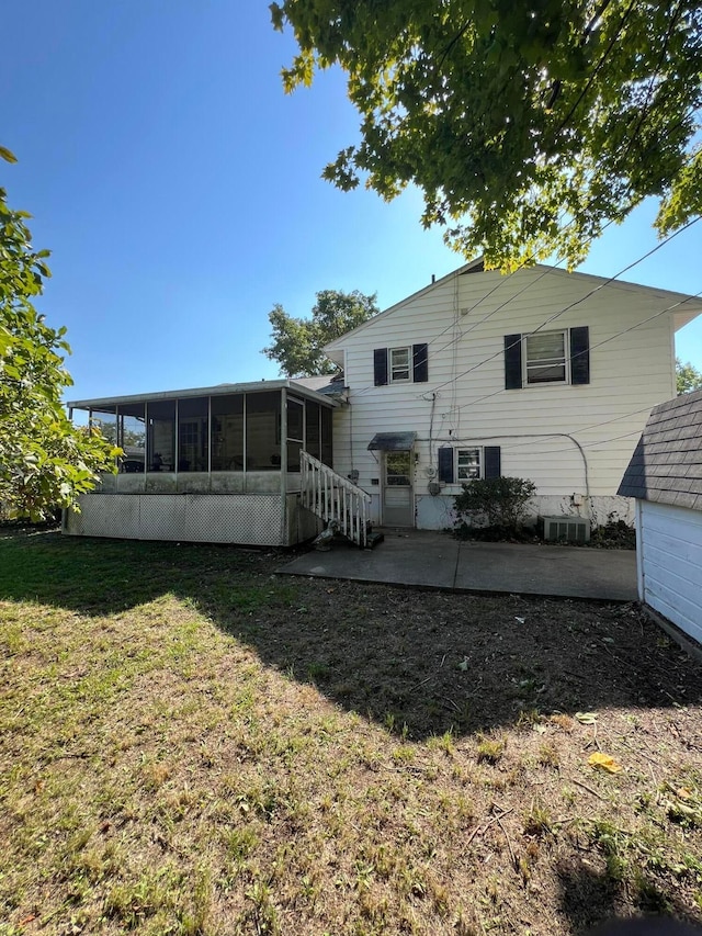 rear view of property featuring a yard, a patio, central air condition unit, and a sunroom