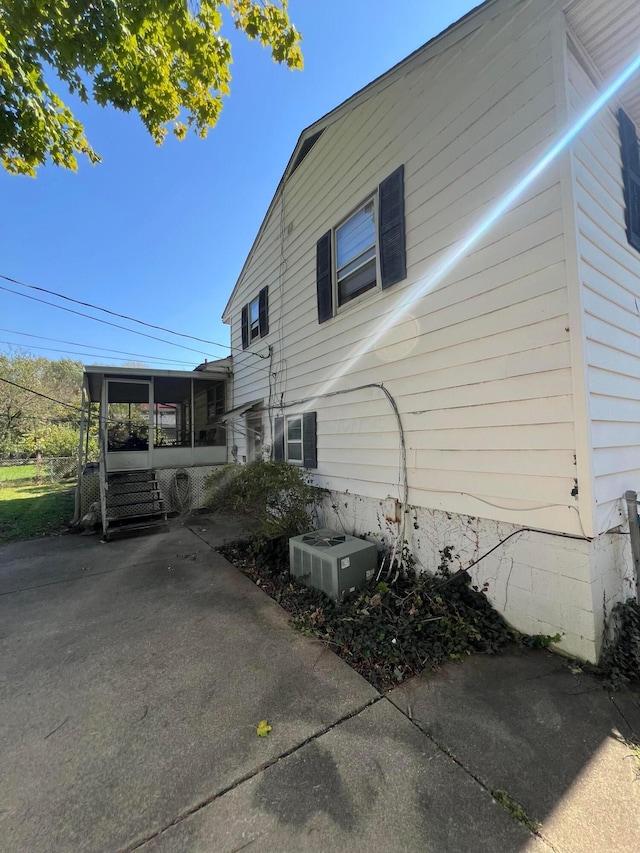 view of side of home featuring a sunroom and cooling unit