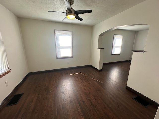 unfurnished room featuring a textured ceiling, dark hardwood / wood-style floors, and ceiling fan