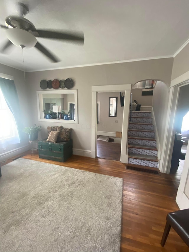 unfurnished living room featuring ceiling fan, dark hardwood / wood-style flooring, and crown molding