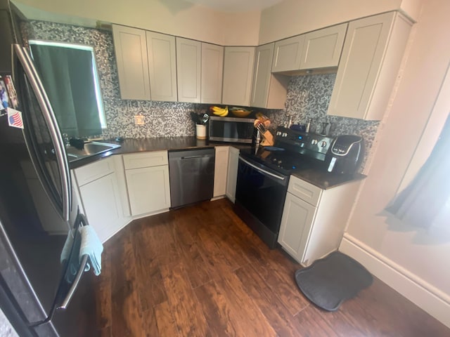 kitchen featuring black appliances, dark hardwood / wood-style flooring, sink, and tasteful backsplash