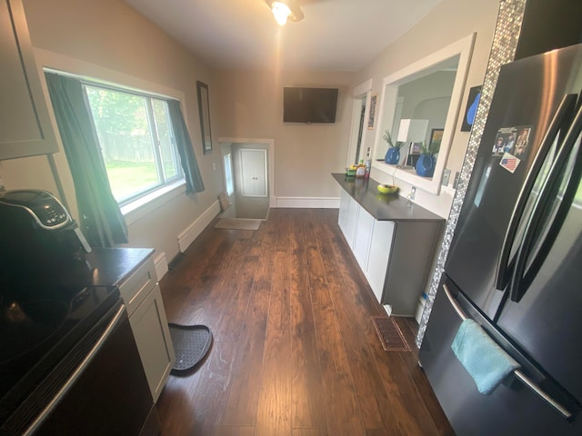 kitchen featuring white cabinets, dark hardwood / wood-style flooring, and stainless steel refrigerator