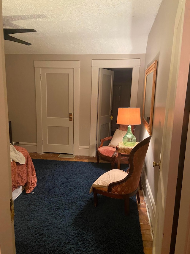 sitting room featuring carpet flooring, a textured ceiling, vaulted ceiling, and ceiling fan