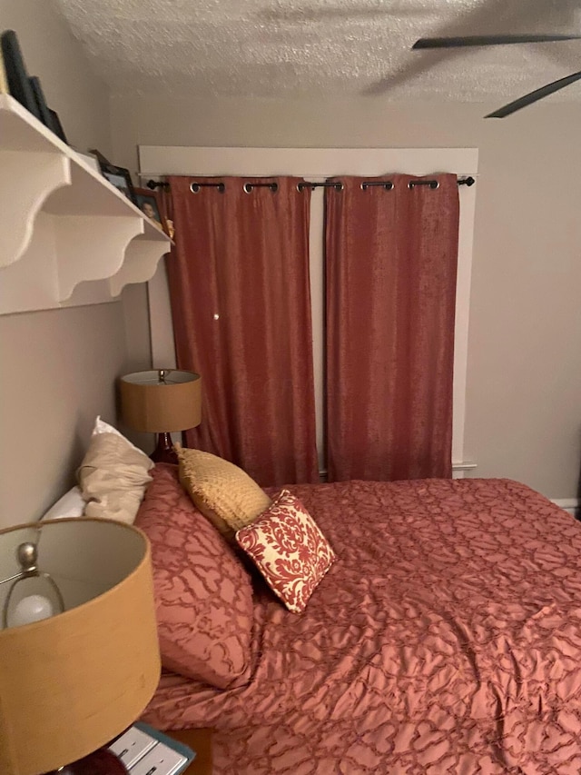 bedroom with a textured ceiling and ceiling fan