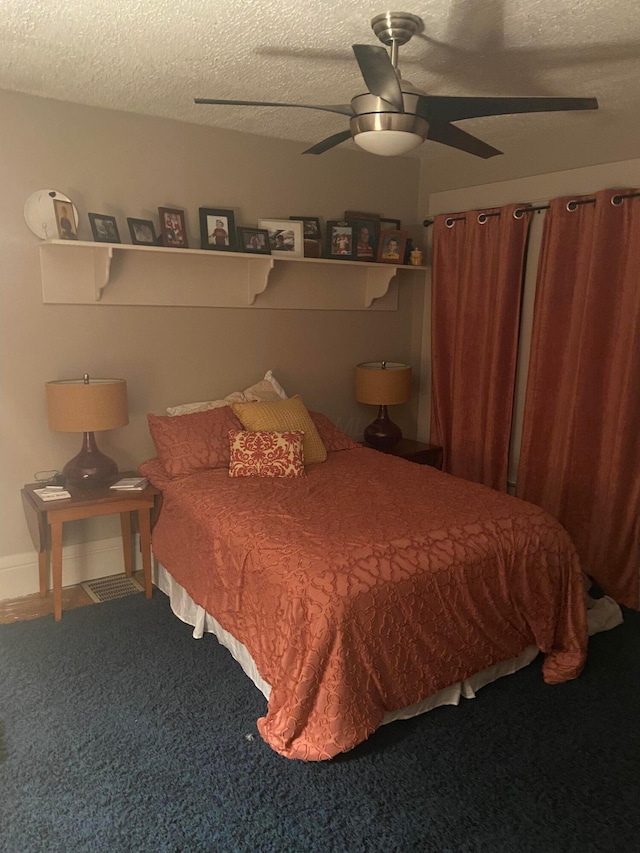 carpeted bedroom with a textured ceiling and ceiling fan