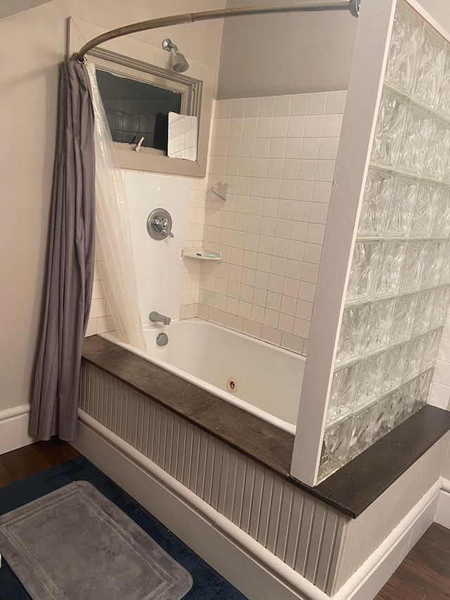 bathroom with hardwood / wood-style floors and shower / tub combo with curtain