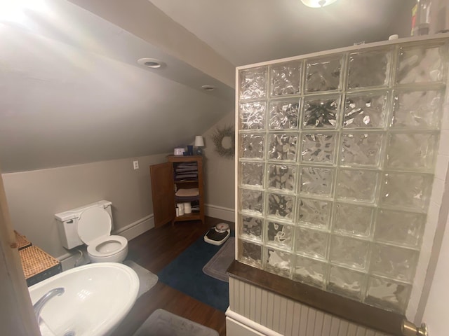 bathroom featuring sink, vaulted ceiling, toilet, walk in shower, and wood-type flooring