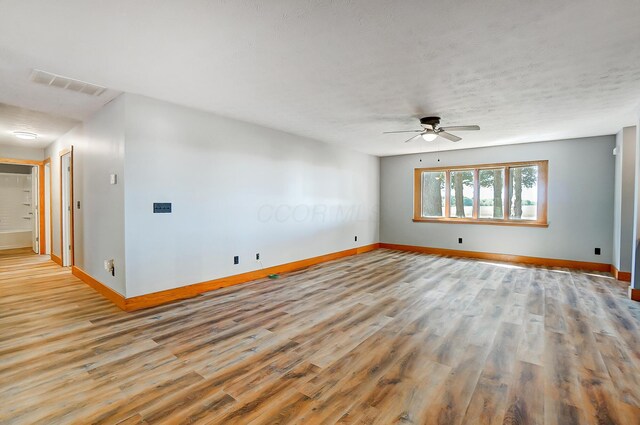 spare room featuring ceiling fan, light hardwood / wood-style flooring, and a textured ceiling