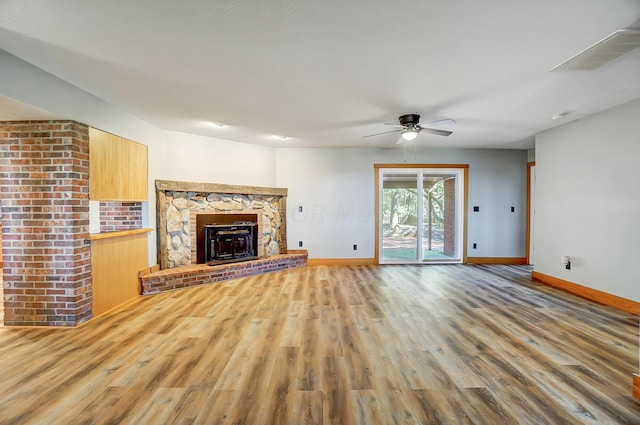 unfurnished living room with a fireplace, ceiling fan, and hardwood / wood-style floors