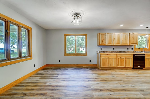 kitchen with dishwasher, light brown cabinets, sink, decorative light fixtures, and light hardwood / wood-style floors