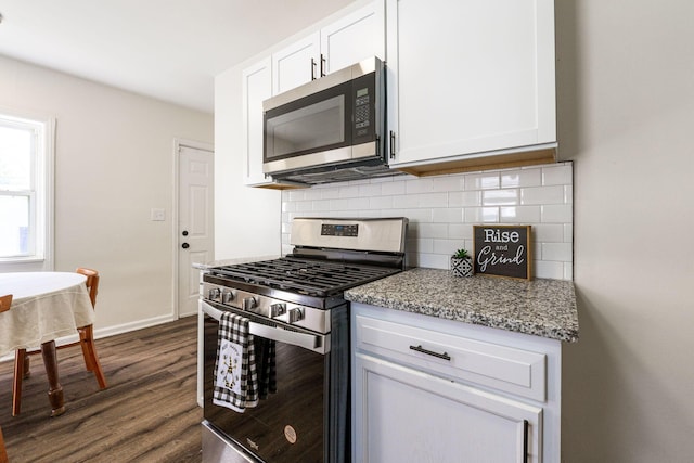 kitchen with decorative backsplash, light stone counters, stainless steel appliances, dark hardwood / wood-style floors, and white cabinetry