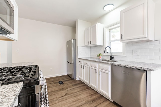 kitchen featuring white cabinets, wood-type flooring, sink, and stainless steel appliances