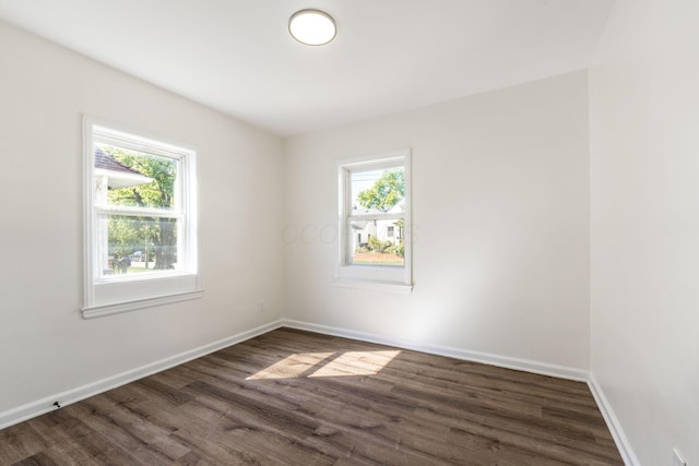 spare room with dark hardwood / wood-style flooring and plenty of natural light