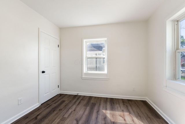 spare room with dark hardwood / wood-style flooring and plenty of natural light