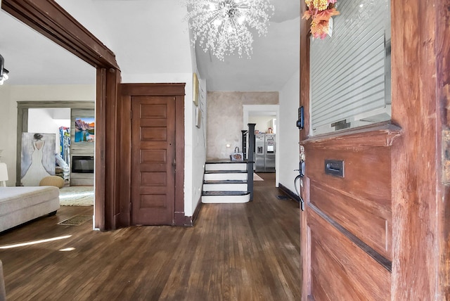 hall featuring a notable chandelier and dark wood-type flooring