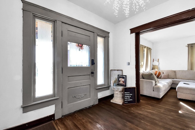 entrance foyer featuring dark wood-type flooring and an inviting chandelier