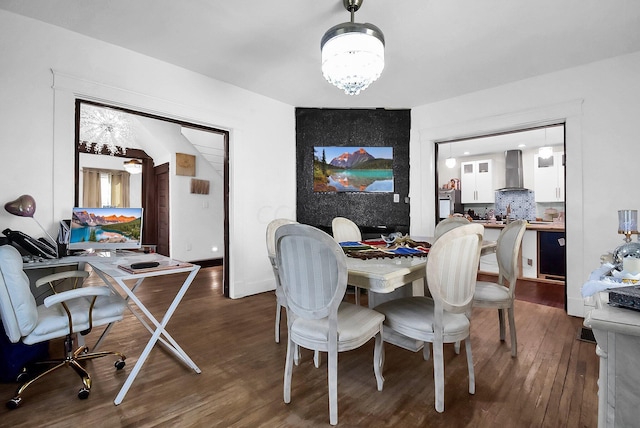 dining area with a chandelier and dark wood-type flooring