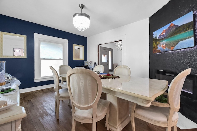 dining space with dark hardwood / wood-style flooring and an inviting chandelier