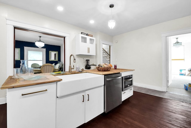 kitchen with white cabinetry, dark hardwood / wood-style flooring, a notable chandelier, decorative light fixtures, and appliances with stainless steel finishes