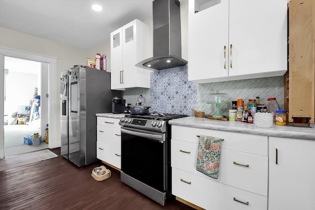 kitchen featuring dark hardwood / wood-style flooring, backsplash, stainless steel appliances, wall chimney range hood, and white cabinets