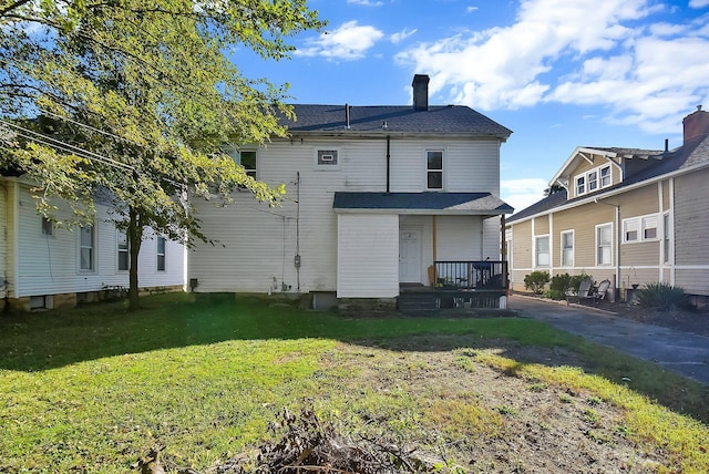 rear view of property featuring a lawn