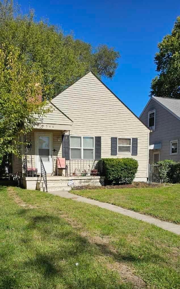 bungalow-style home with a front yard