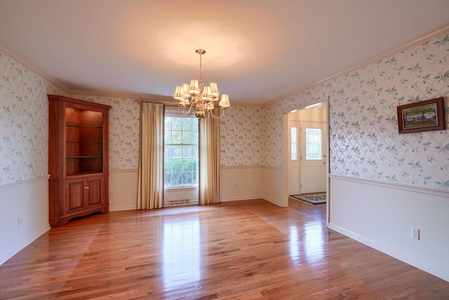 unfurnished dining area featuring a chandelier, light wood-type flooring, and ornamental molding