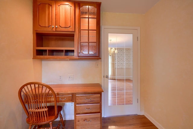 home office with light wood-type flooring and built in desk