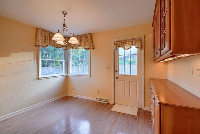 interior space featuring plenty of natural light, a chandelier, and light hardwood / wood-style flooring